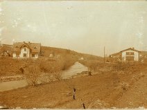 na záběru vlevo je budova Deštné č. 131 a v pravo 132, potok Hvozdnice
